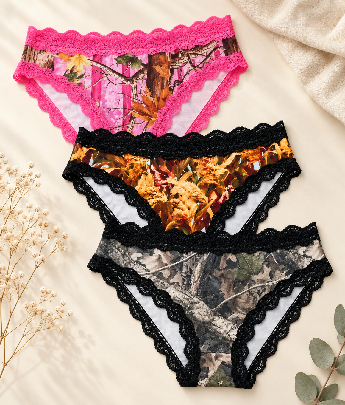 Wilderness Dreams camo panty 3-pack in Magenta Woods, Golden Marsh and Faded, with lace trim on a cream flat lay background